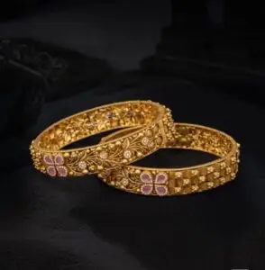 Handcrafted luxury gold bangles with intricate floral design and gemstone detailing by RoyalJain